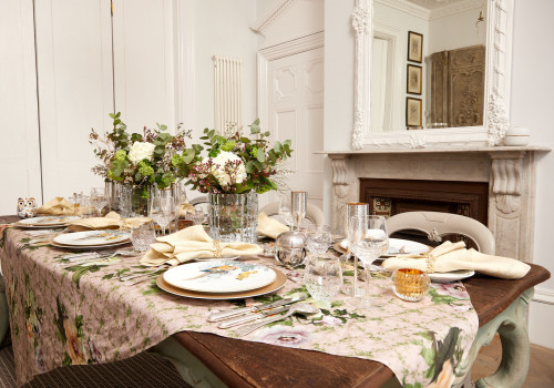 lavish dinner on a wooden table and plates, flowers, wine glasses and forks rested on the table